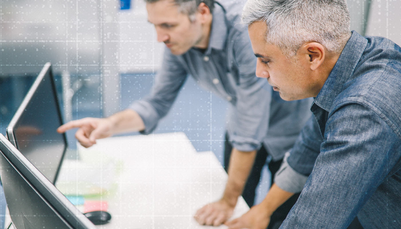 two businesspeople working around a computer in the office